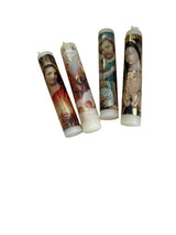 Four prayer candles with religious designs on a wooden surface