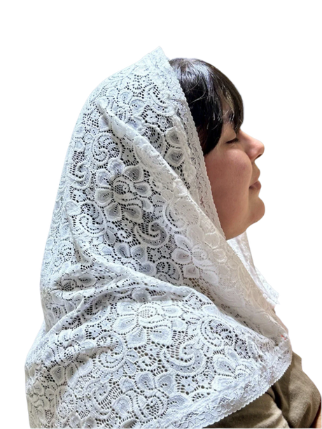 Person wearing a white lace headscarf in a store setting